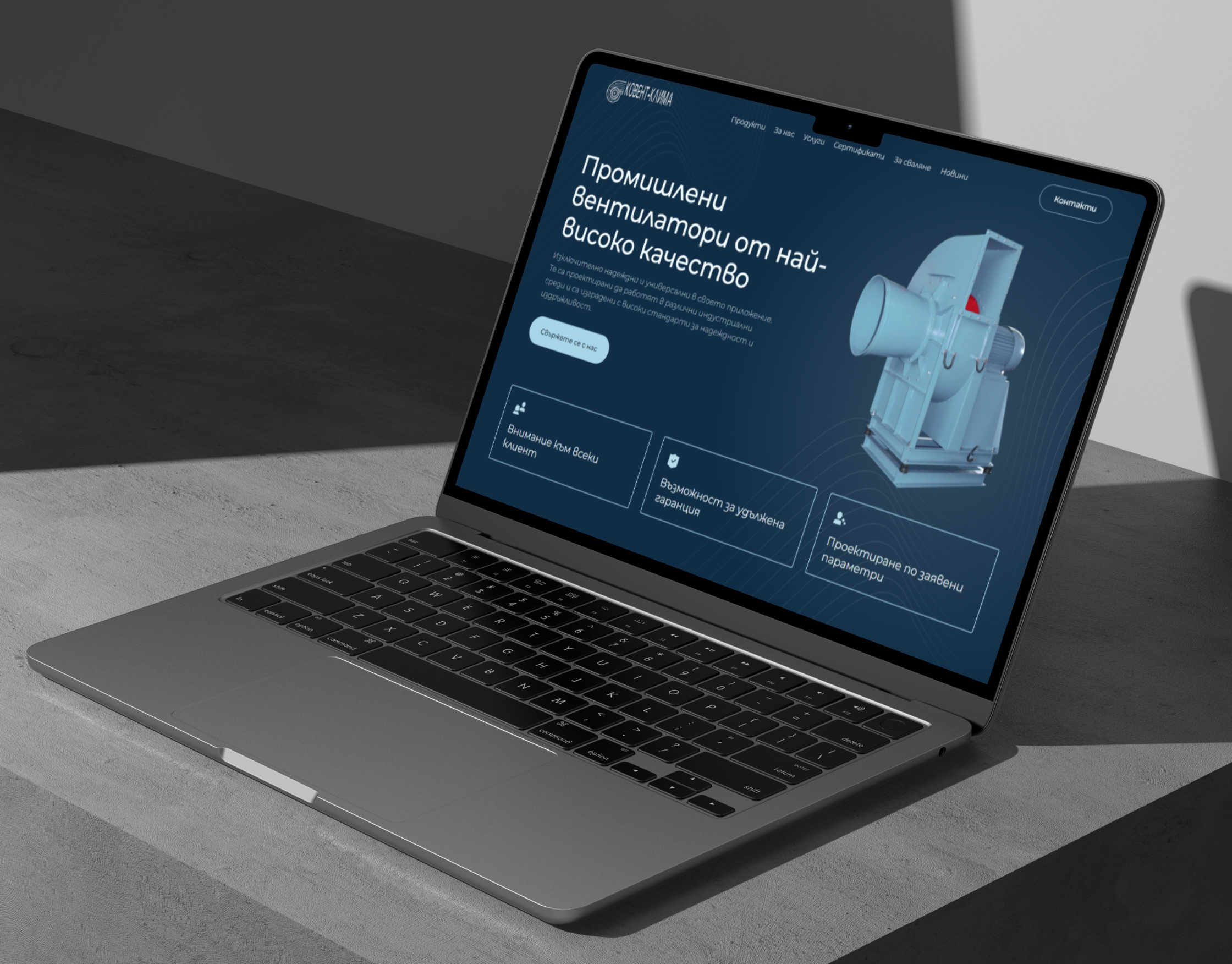 Kovent Klima homepage on an angled laptop mockup on a grey concrete surface, showing the 3D industrial fan hero