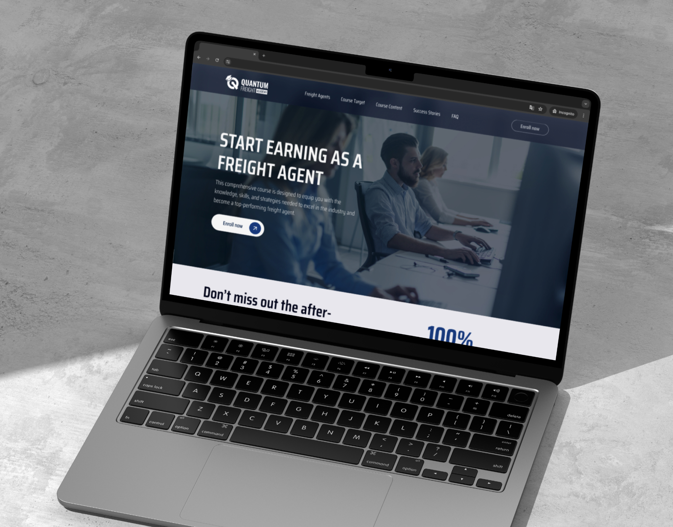Quantum Freight landing page on a laptop mockup set on a grey concrete surface, showing the freight agent hero