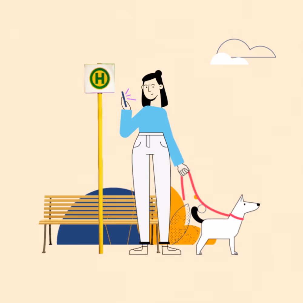 A person wearing blue outerwear and white pants stops at a bus stop with a dog on a red leash, holding their smartphone in their hand.