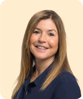 A woman in a blue shirt smiling at the camera.