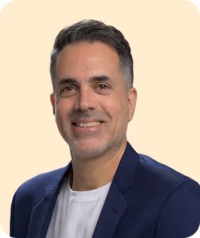 A man in a blue jacket smiles at the camera.
