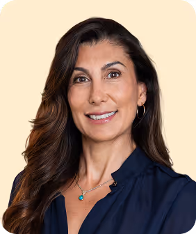 A woman in a blue shirt smiling for the camera.