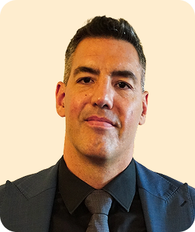 A man in a suit and tie looking at the camera.