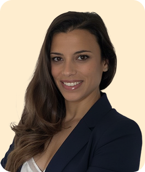 Retrato de una mujer sonriente con cabello largo y oscuro, vestida con blazer azul y blusa blanca.