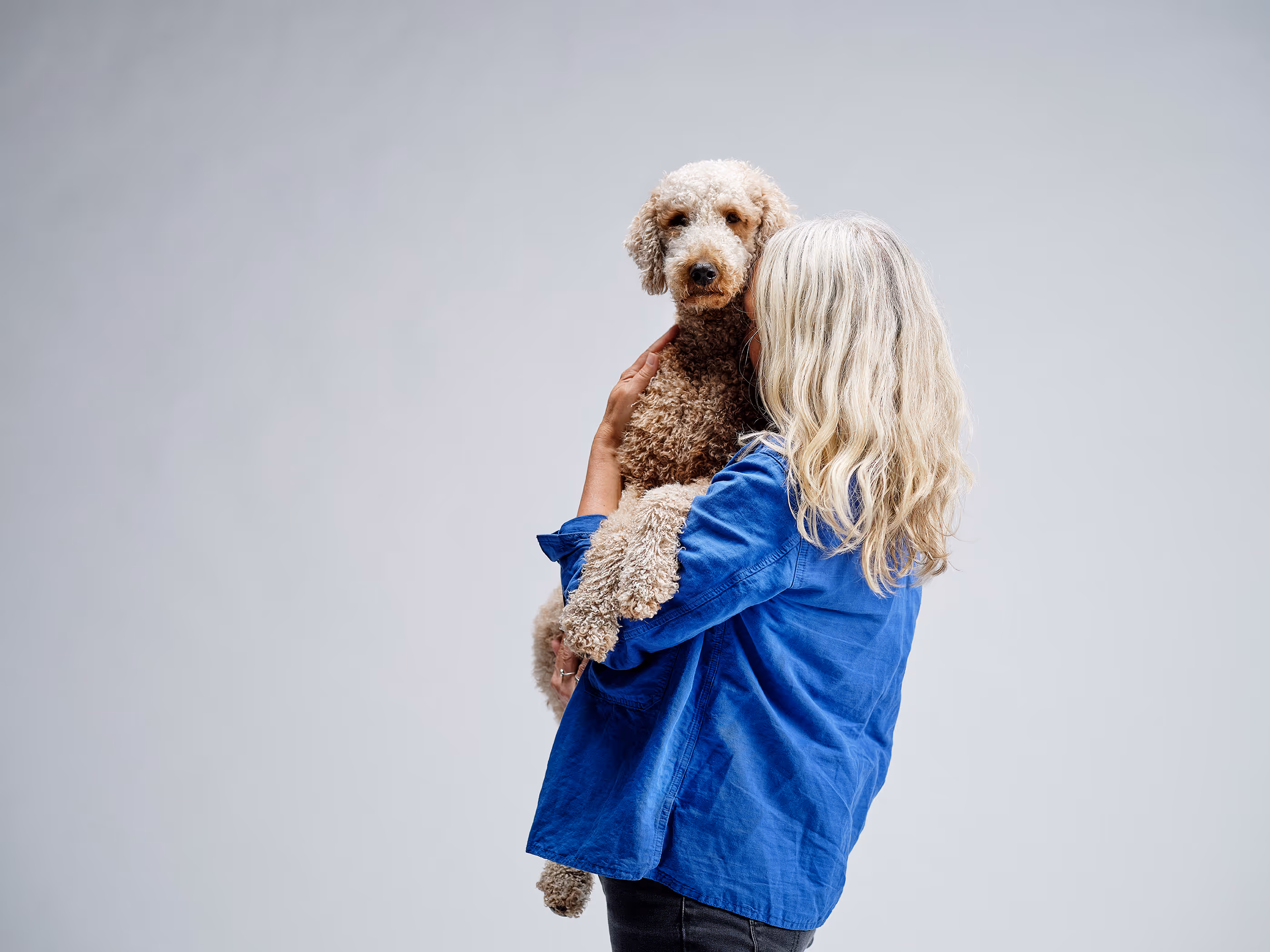 En kvinna kramar om sin hund.