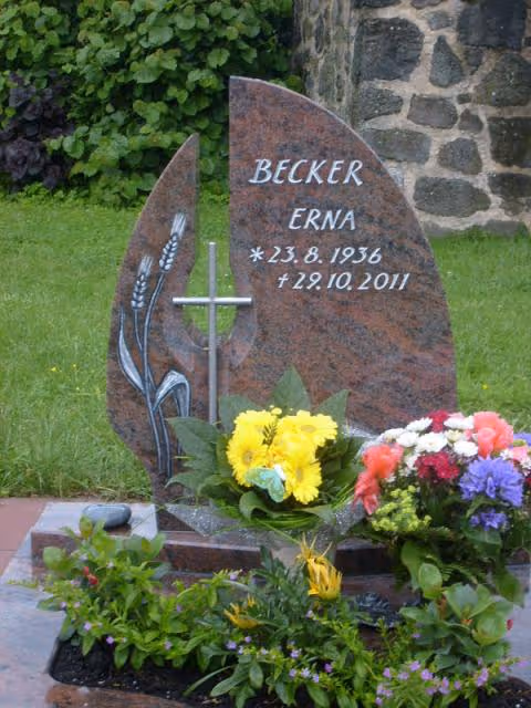 Ein Grab mit Grabstein und Blumen auf dem Grab