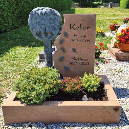 Urnengrab mit Bepflanzung. Grabstein mit Baum-Motiv