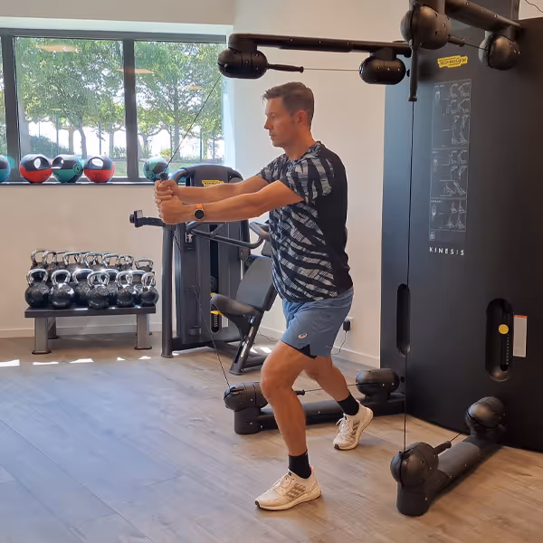 Ole Nauert, Inhaber und Therapeut der Rheinblick Physio, zeigt im Trainingsraum eine Rumpfstabilisationsübung an der Kinesis.