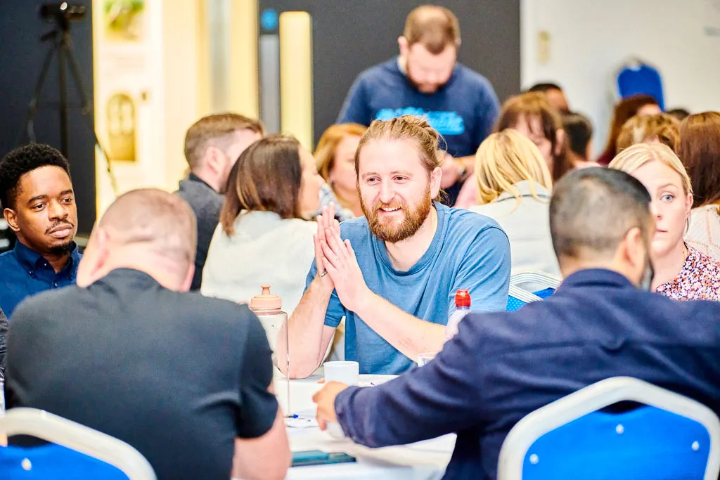 Colleague smiling while engaging in conversation, reflecting positive interaction and camaraderie.