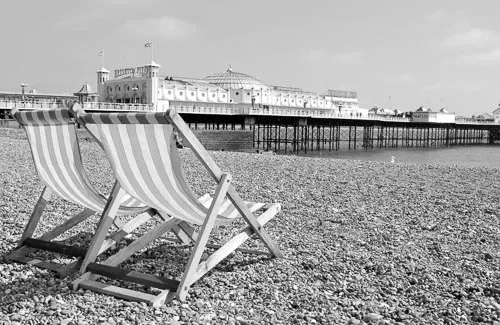 Brighton Beach with the pier in the distance in black and white.
