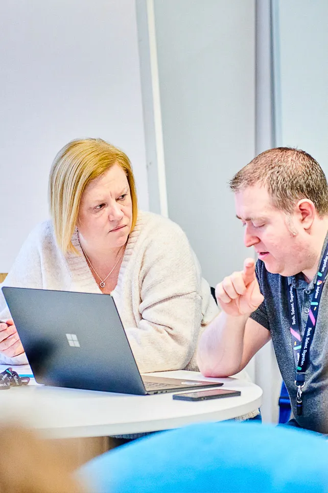 Two colleagues strategising to resolve an issue together in a collaborative manner.