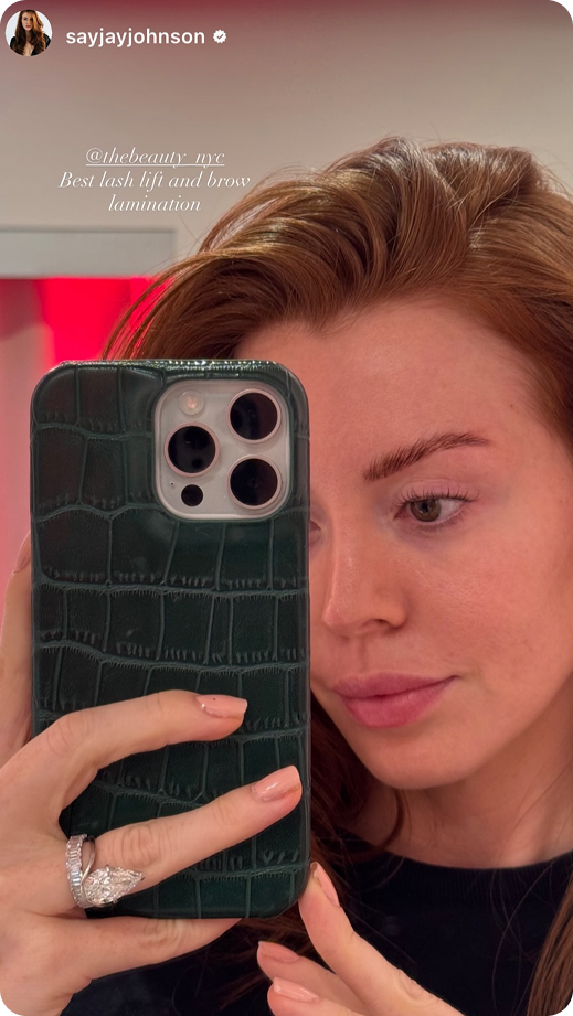 Woman with styled eyebrows and natural makeup taking a selfie with a green textured phone case.