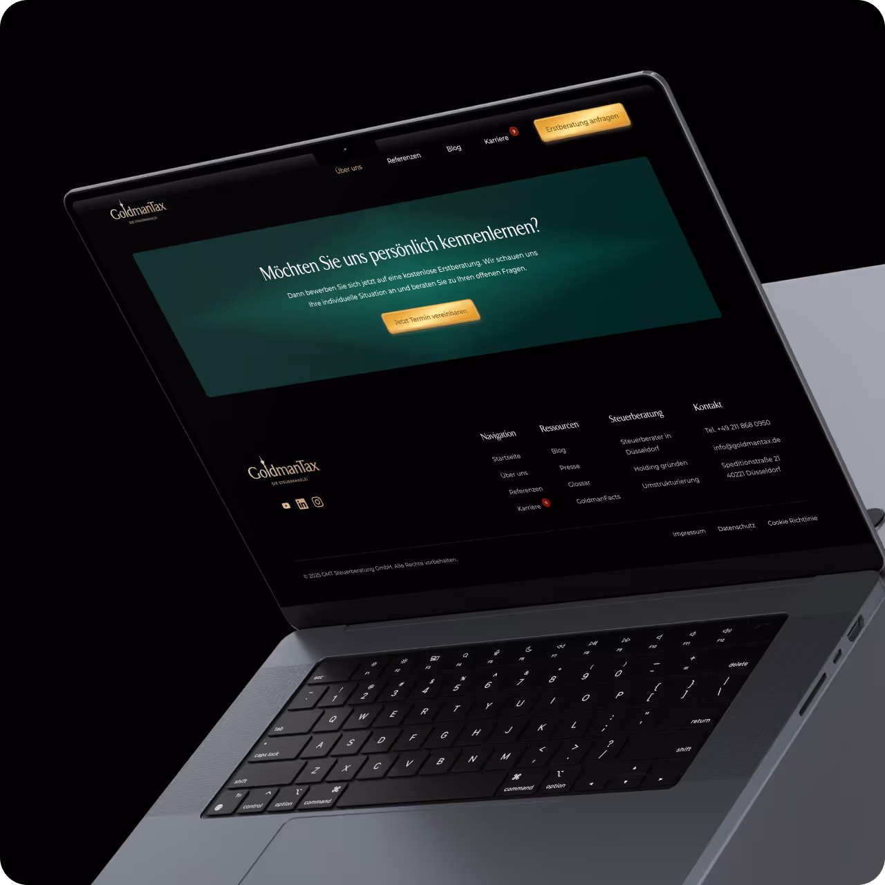 Laptop zeigt eine Webseite von GoldmanTax mit einem grünen Banner und Text zum kostenlosen Erstberatungstermin.