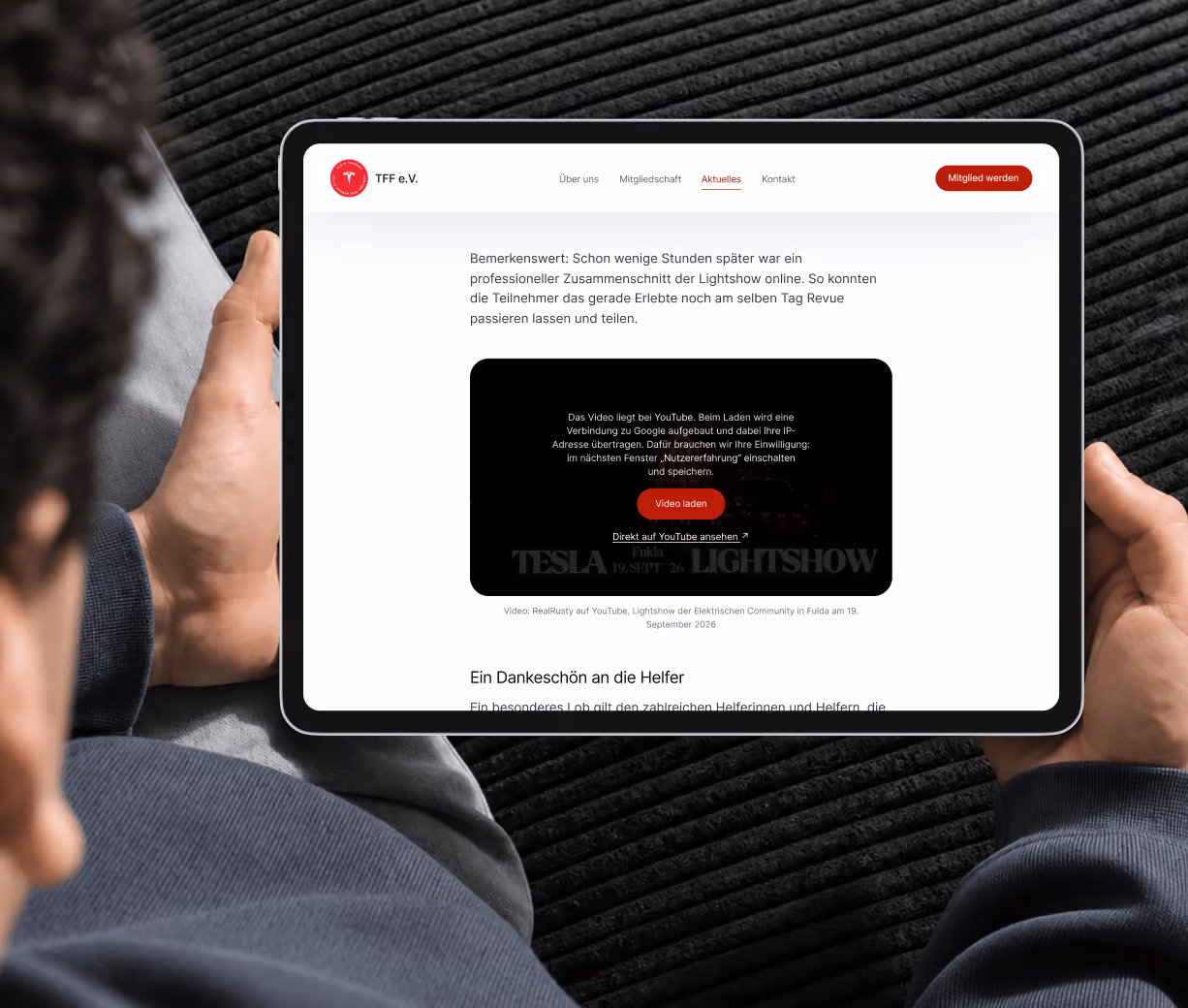 Person holding a tablet showing a TFF post with an embedded video that only loads after consent.