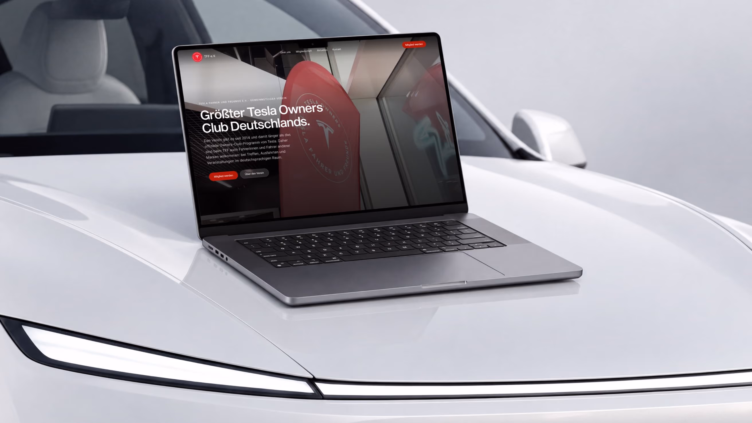 Laptop on the hood of a white Tesla showing the new TFF e.V. website “Germany’s largest Tesla Owners Club”.