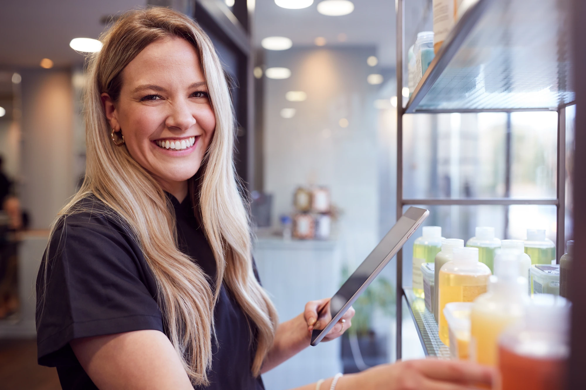 Salon professional using a tablet to manage appointments.
