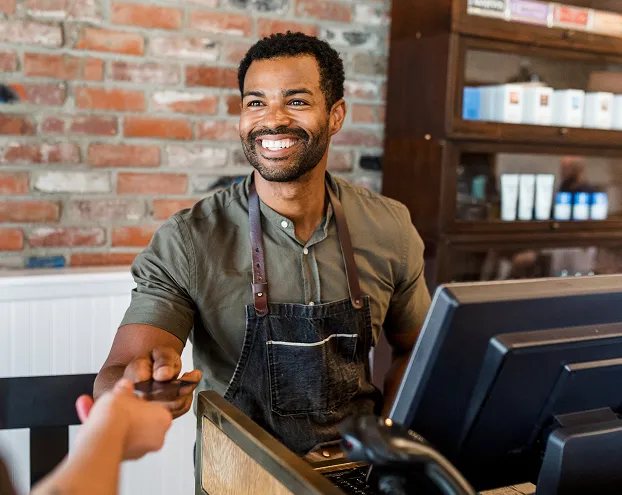 Barber managing appointments and checkout with salon booking software.