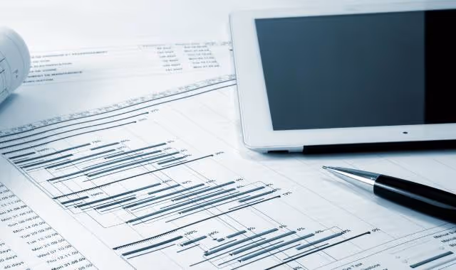 Photo of a budget, a pen, and a tablet