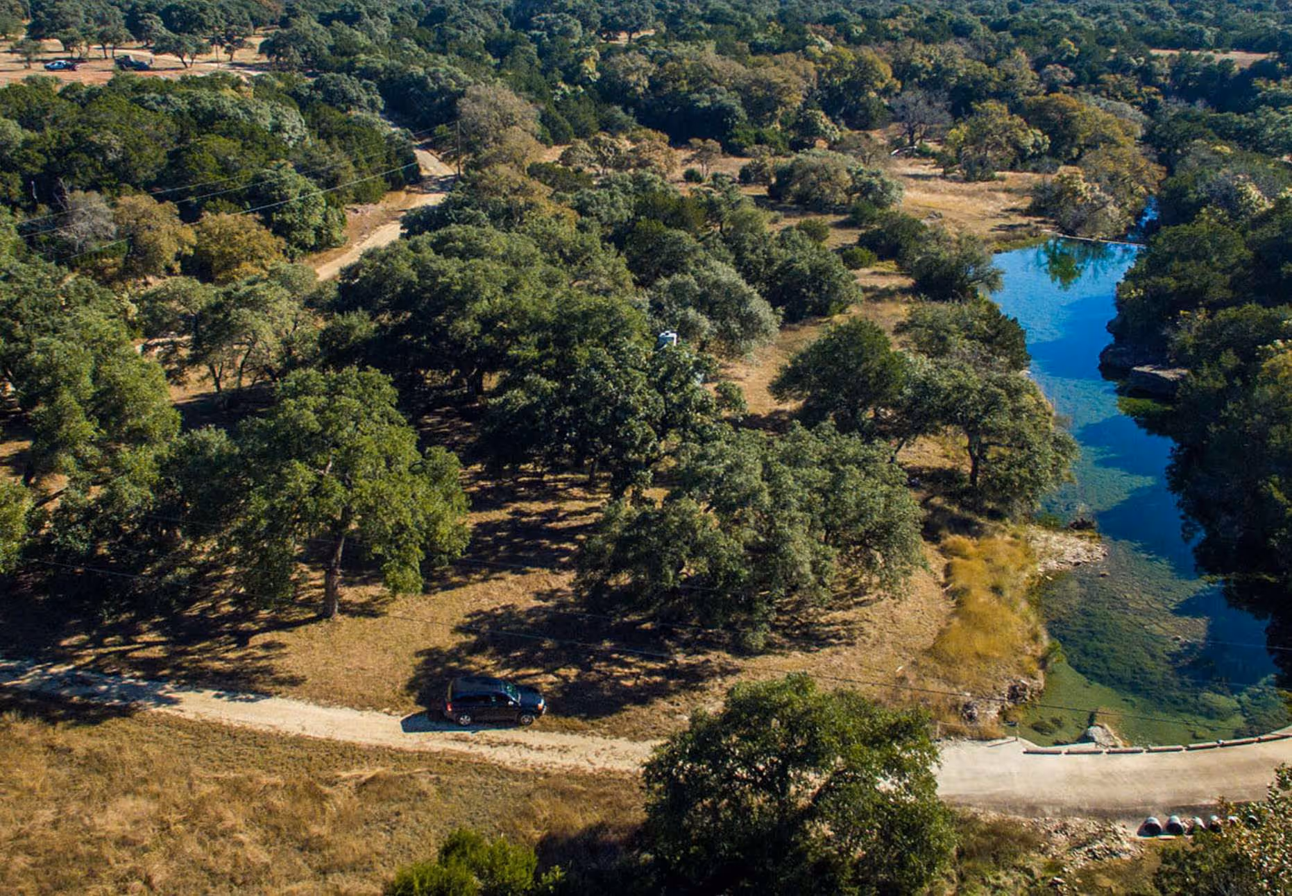 Aerial photo of a homesite with a beautiful creek or pond running through it