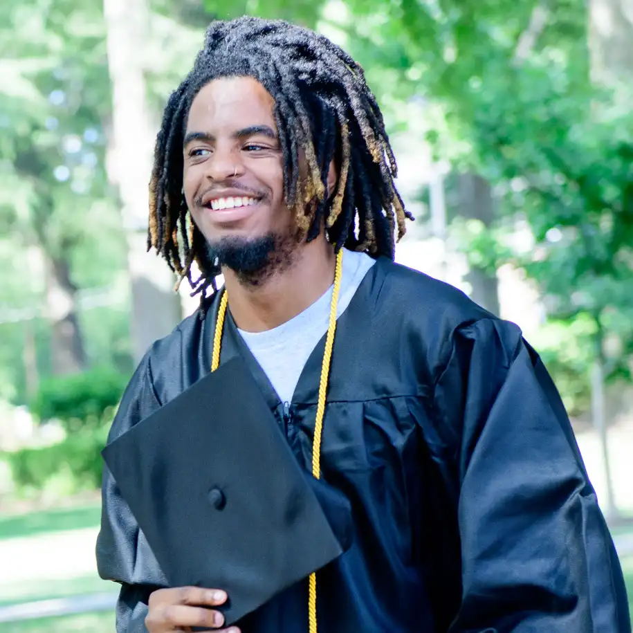 A male graduate smiles