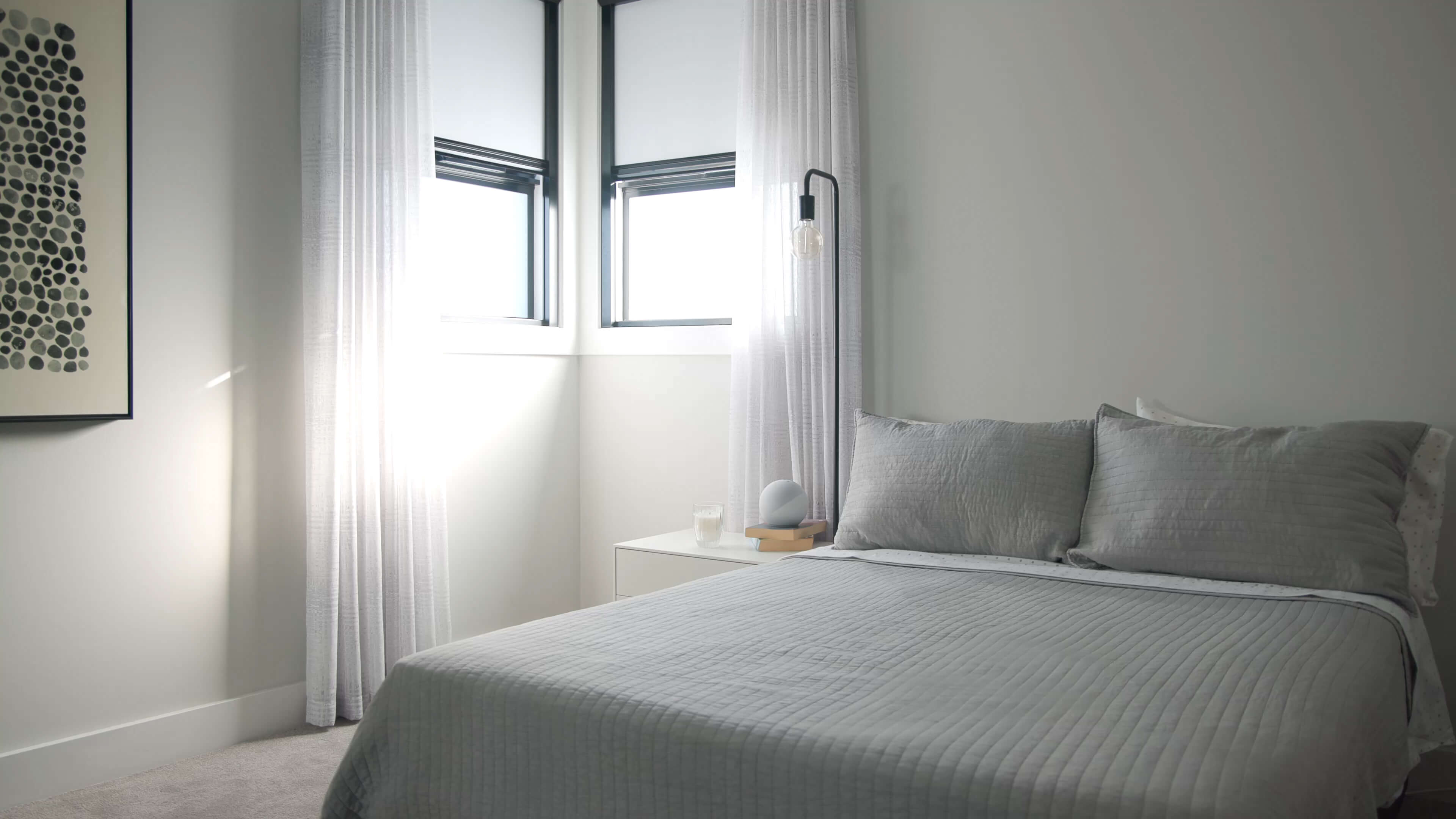 Bedroom with gray luxury bedding and window with total blackout shade