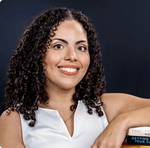 a woman holding a stack of books and smiling