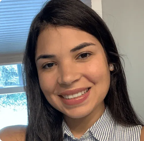 a woman with long black hair smiling at the camera