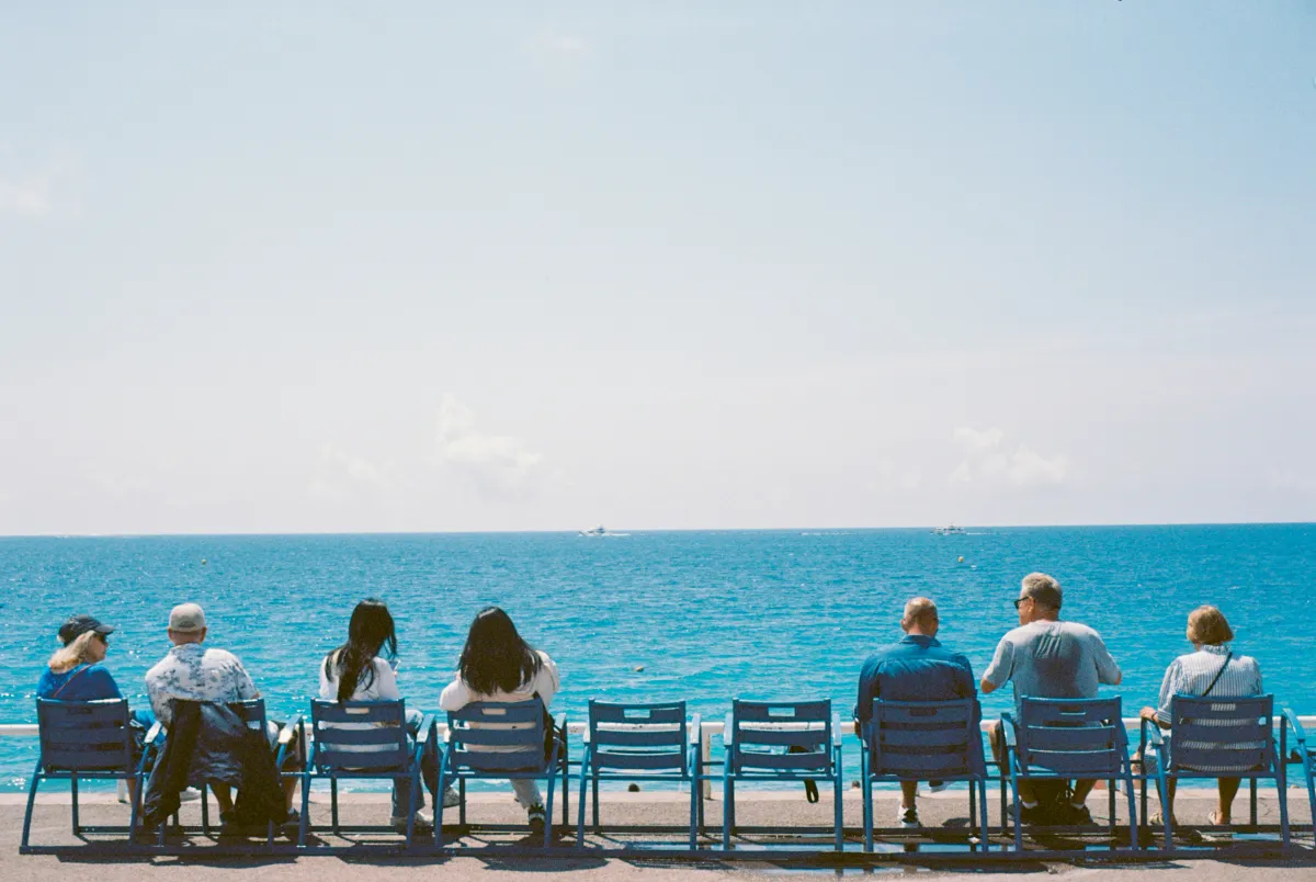 Plusieurs générations face à la mer, illustrant la transmission patrimoniale et la préparation de l'avenir familial.
