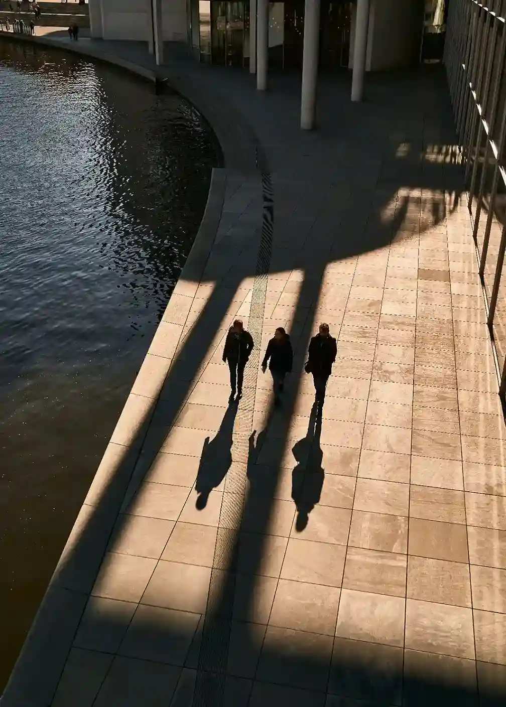 Professionisti che camminano davanti a un moderno edificio adibito a uffici, illustrazione della gestione patrimoniale e dei Family Office