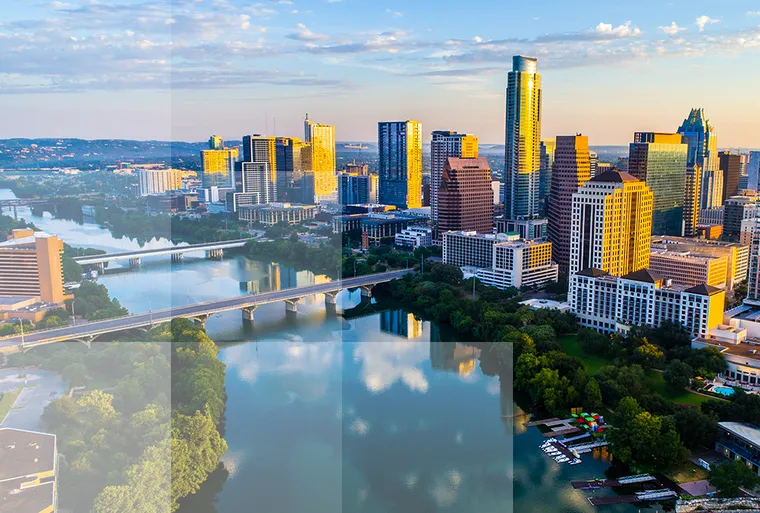 Skyscrapers beside a river, bridges and trees