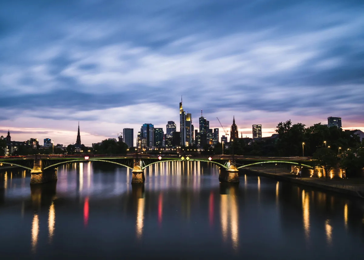 Vue du quartier d’affaires de Francfort au crépuscule, illustrant la dimension internationale du Private Equity
