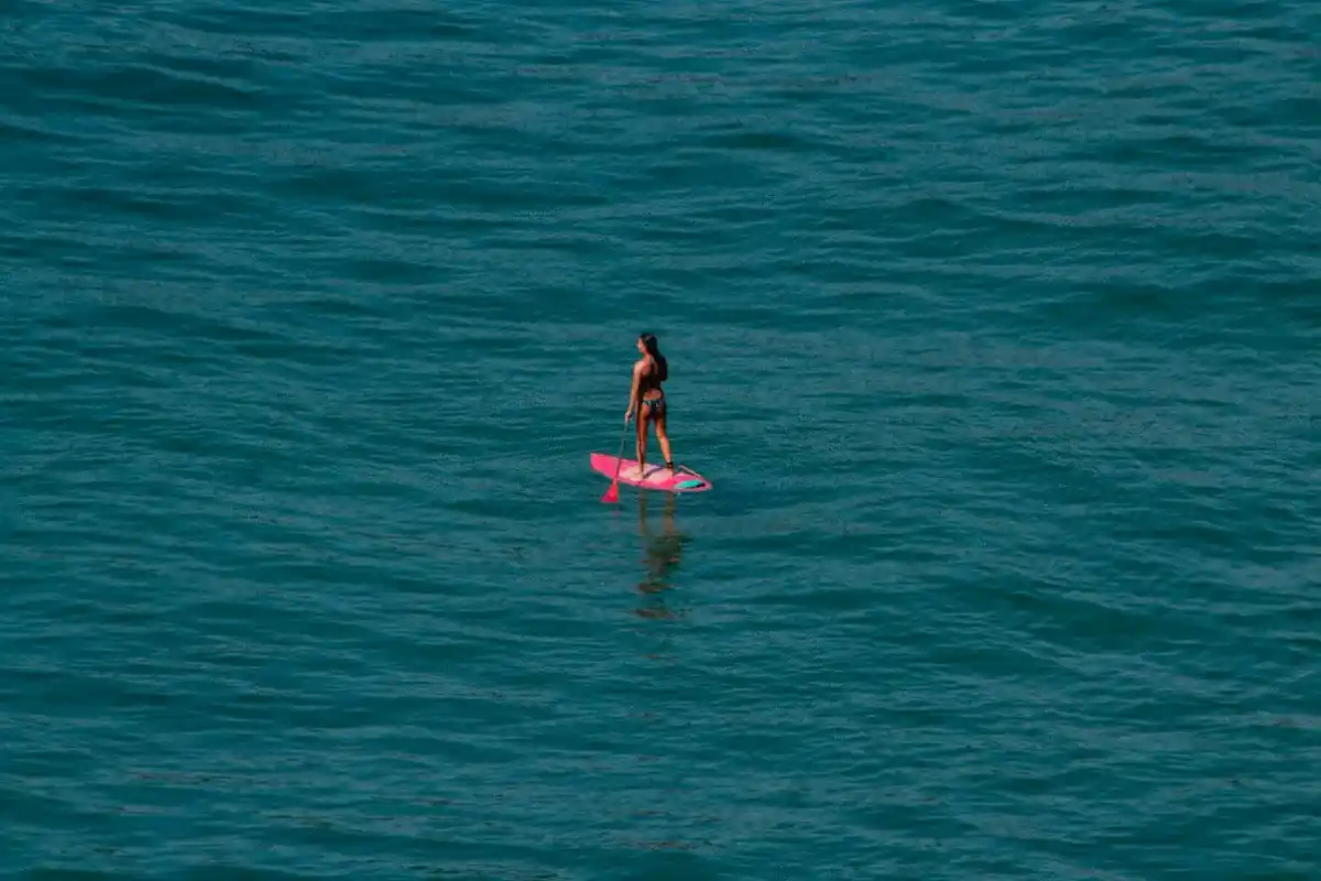 Pratiquante de paddle avançant sur une vaste étendue d’eau, évocation d’une allocation patrimoniale équilibrée