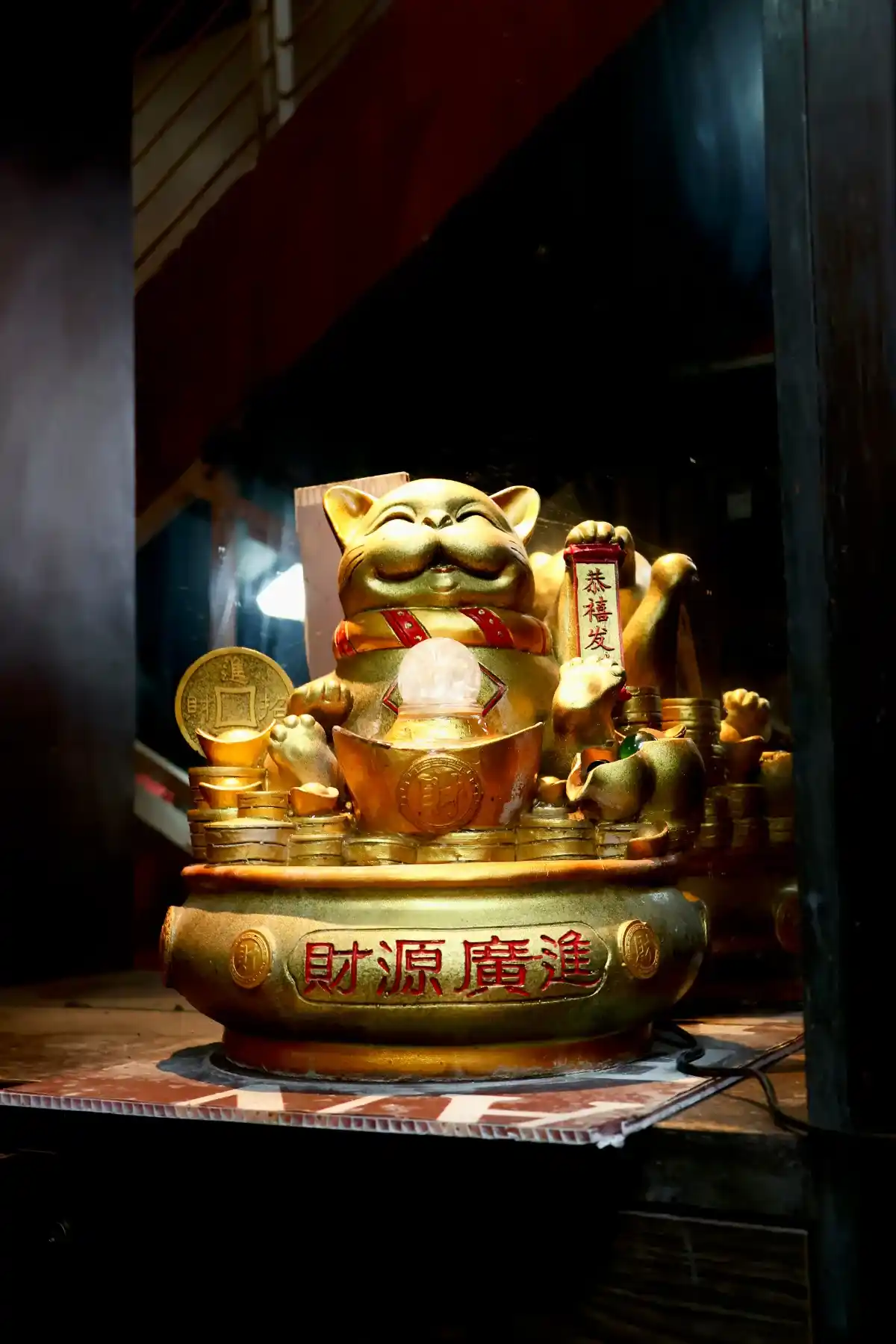 Statuette dorée maneki-neko, évocation de la diversification géographique vers les marchés asiatiques