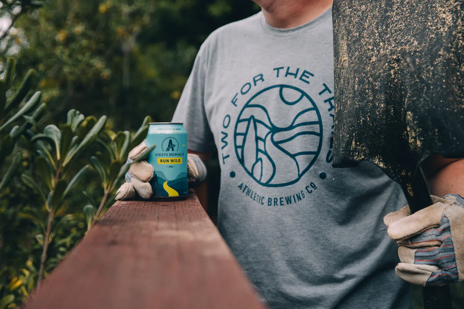 Freiwilliger mit einer Schaufel und einer Dose alkoholfreiem Bier von Athletic Brewing in der Natur