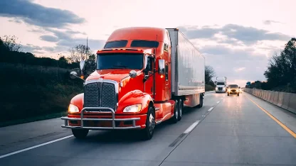 Ein roter Lkw, der auf einer Autobahn fährt, um die Transportlogistik und die KI bei IFS zu veranschaulichen