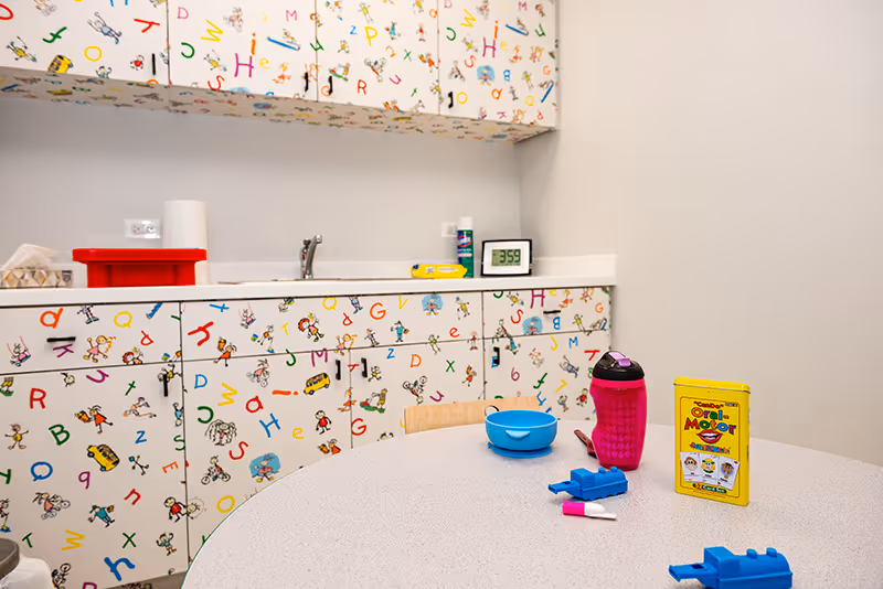 A speech therapy room with oral-motor flash cards and toys used in speech therapy.