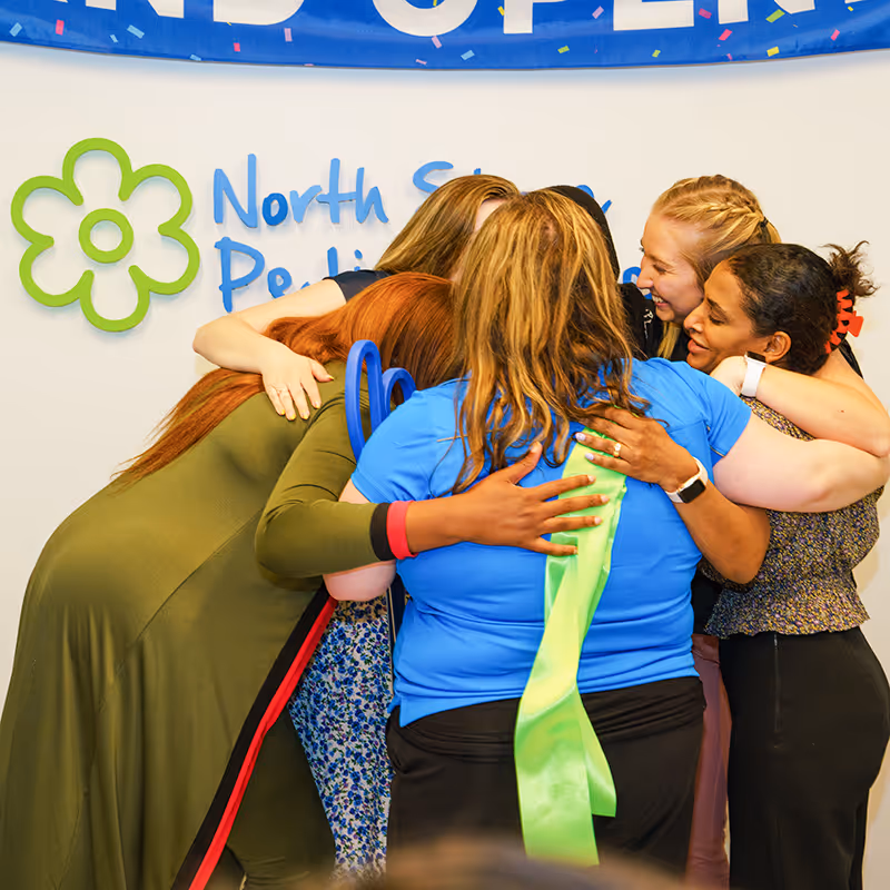Our Arlington Heights team celebrating our center's Grand Opening with a hug.