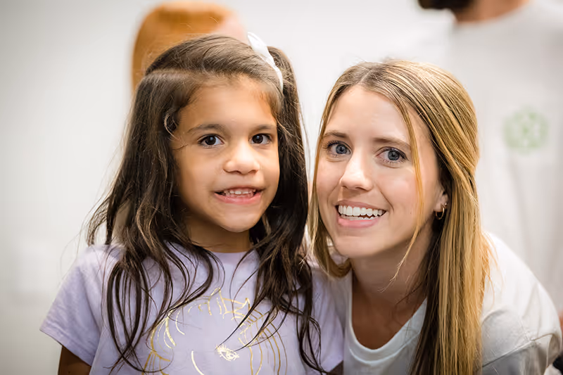 A therapist and small child smiling brightly in the Lincolnwood, IL center.
