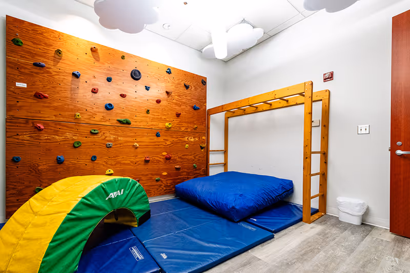 The small gym space at North Shore Pediatric Therapy with a rock climbing wall