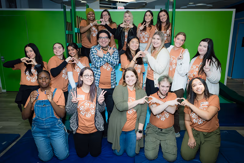 A team of therapists smiling in a group photo at North Shore Pediatric Therapy in Evanston