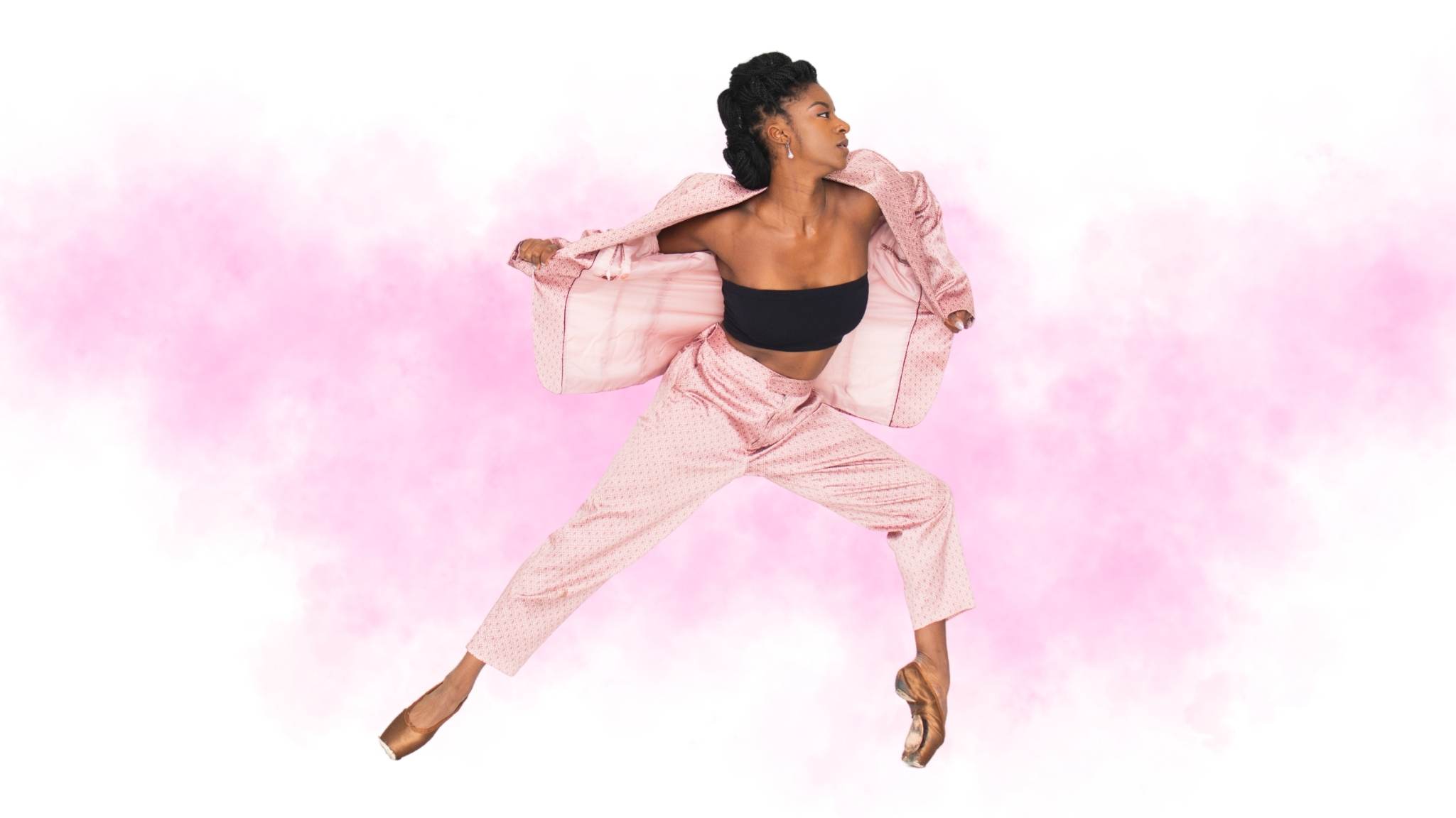 Female dancer posing gracefully with pink jacket against watercolor backdrop