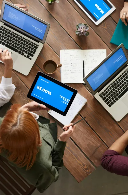 Team sitting around a table with laptops