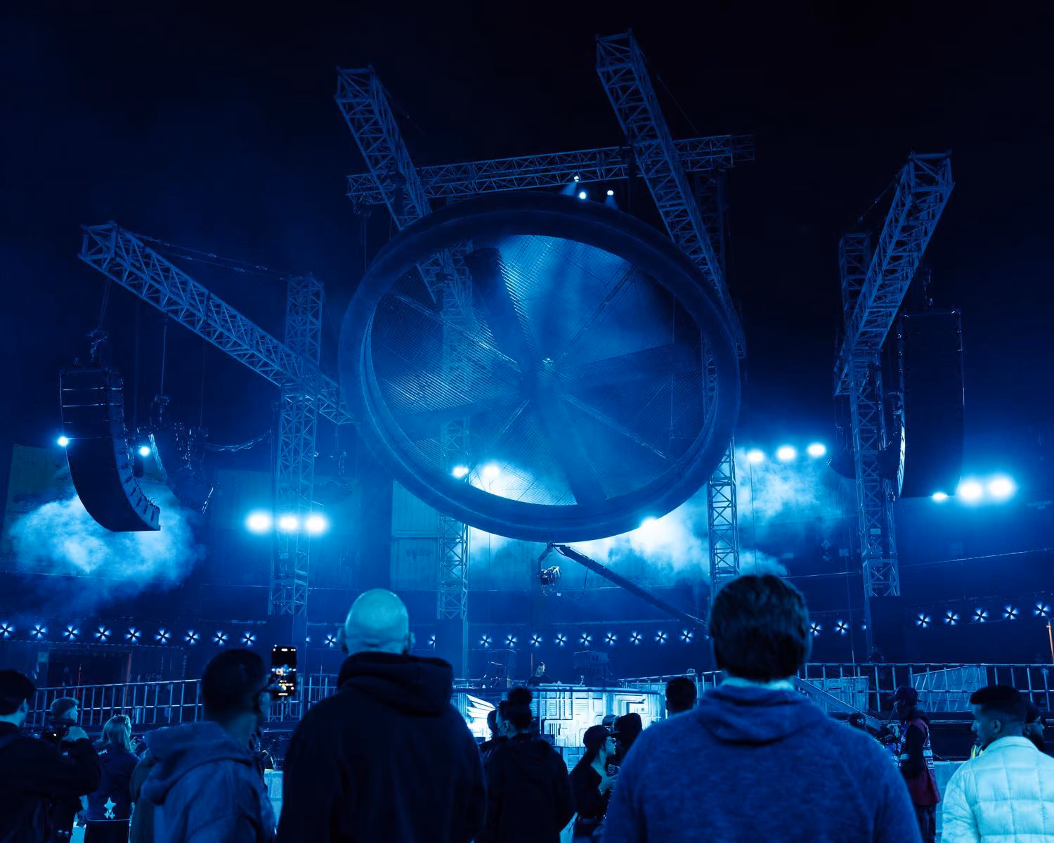 A Cohesion CO12 array, with blue lighting and a bit stage with trussing and a wheel set piece at Soundstorm