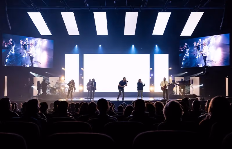 A band playing at a church and people worshipping