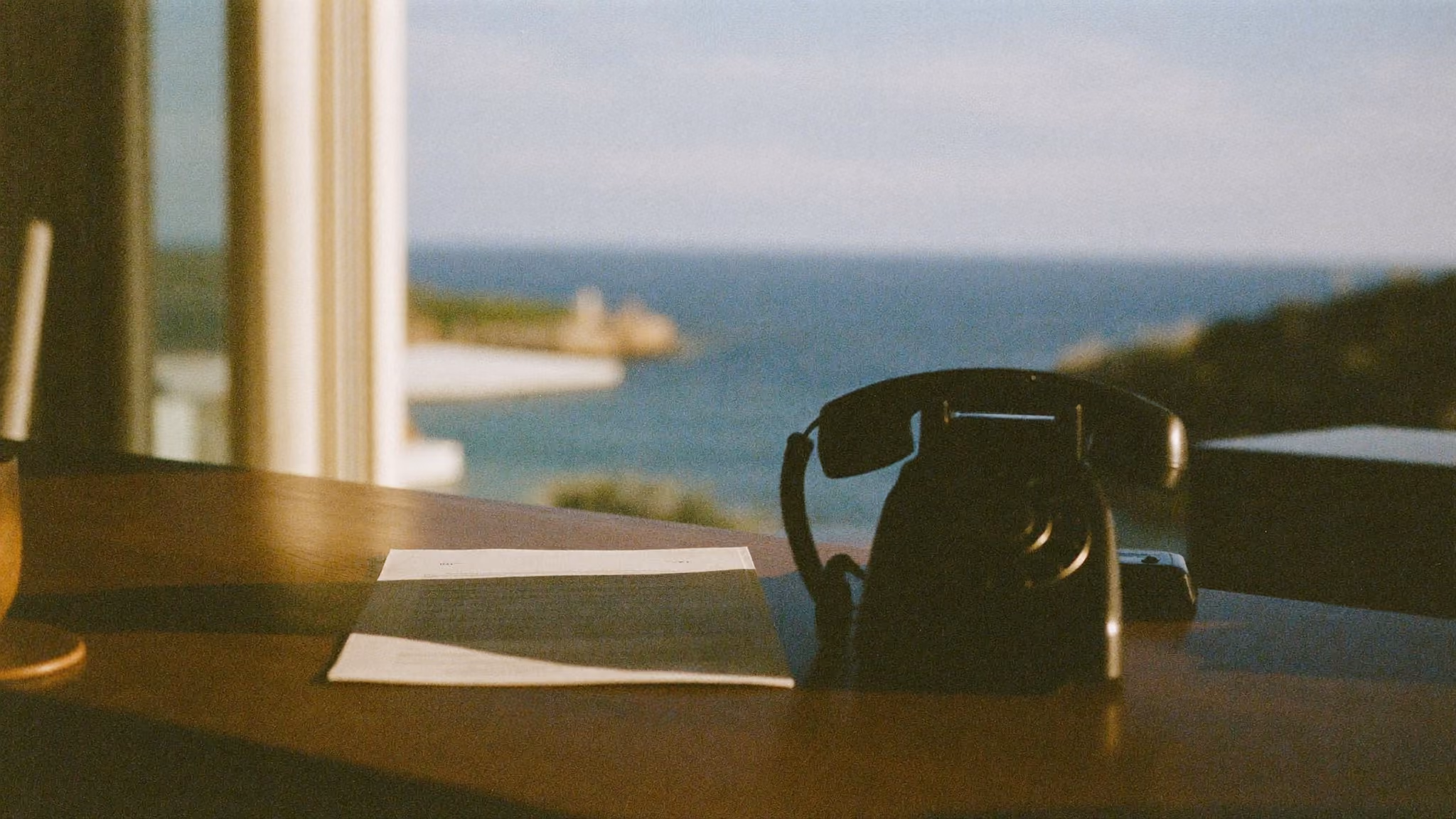 Printed rate sheet on the reception counter of a small hotel beside an old desk telephone