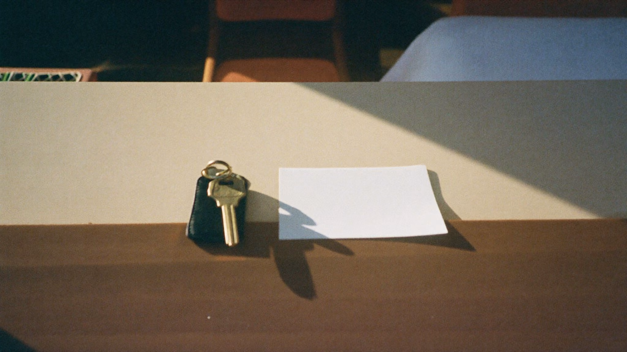 Key card and brass room key resting on the reception counter of a small hotel