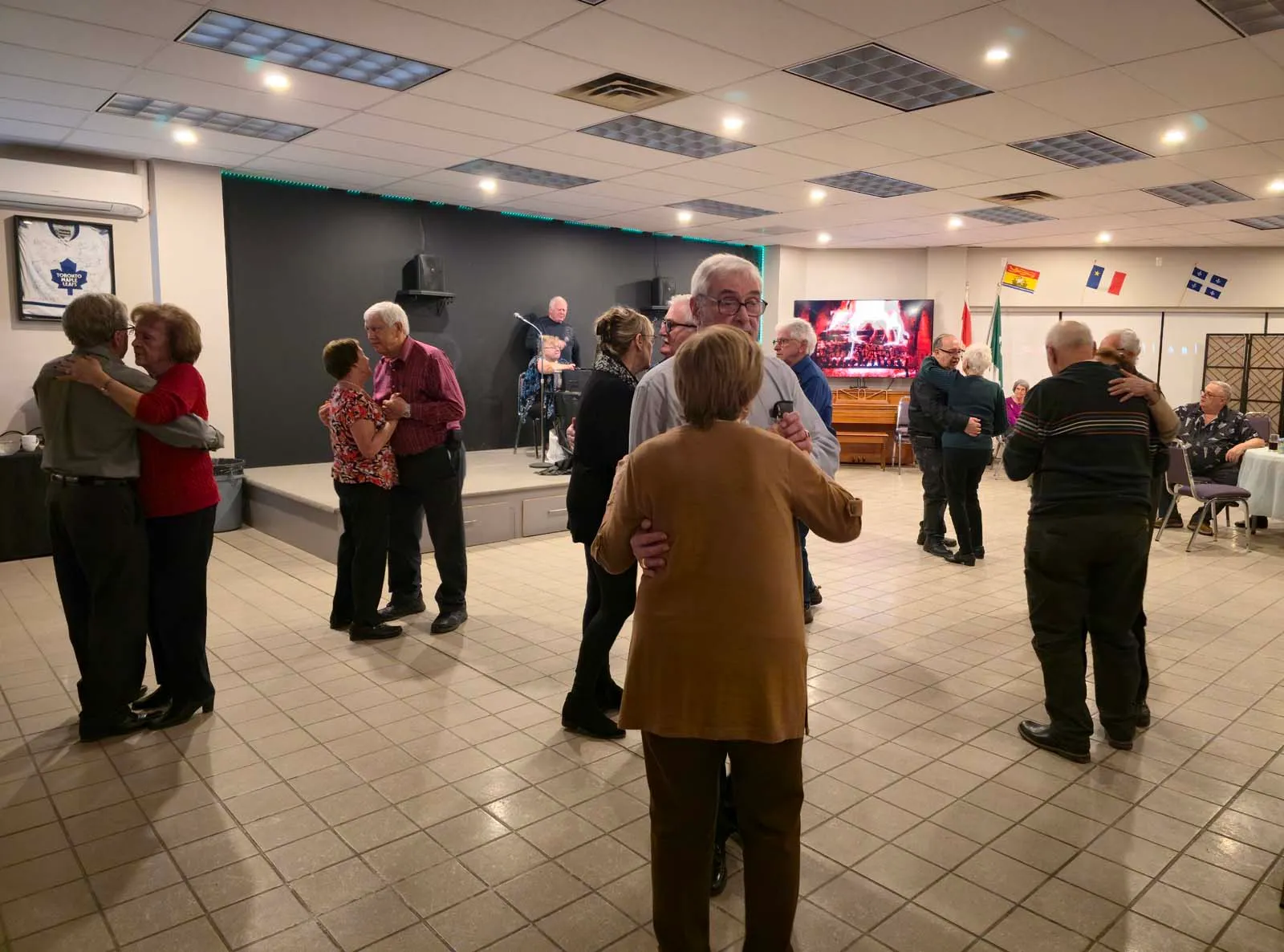 Des membres de L’Amicale dansent en couple sur la piste lors d’une soirée communautaire.