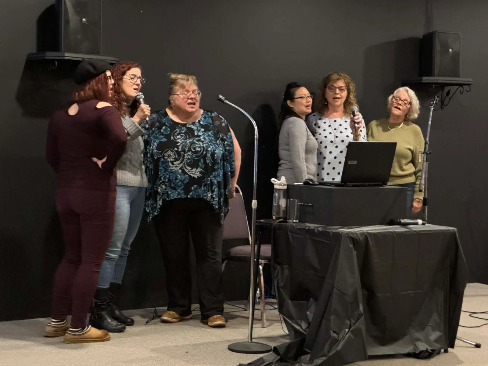 Un membre de L’Amicale chante au micro sur scène lors de la soirée.