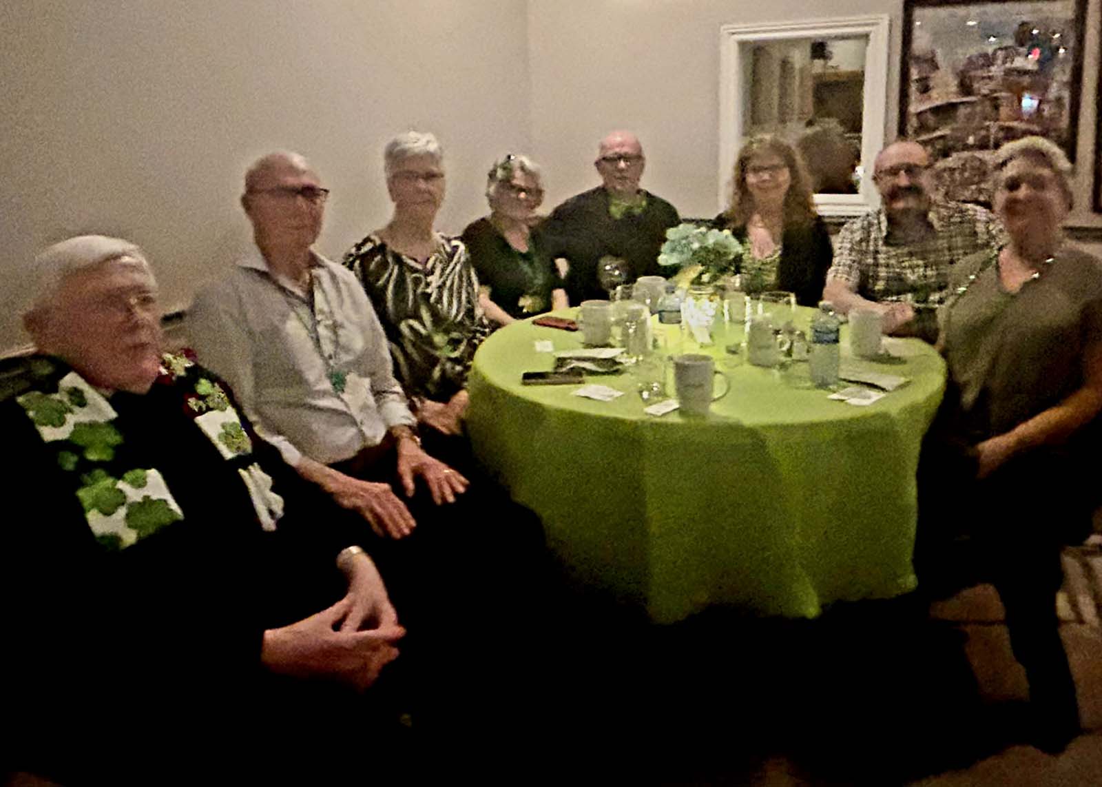 membres d'Amicale assis aux tables décorées pour la Saint-Patrick