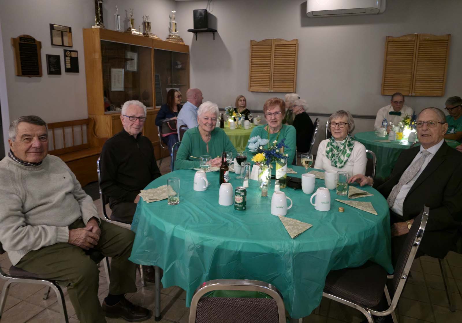membres d'Amicale assis aux tables décorées pour la Saint-Patrick
